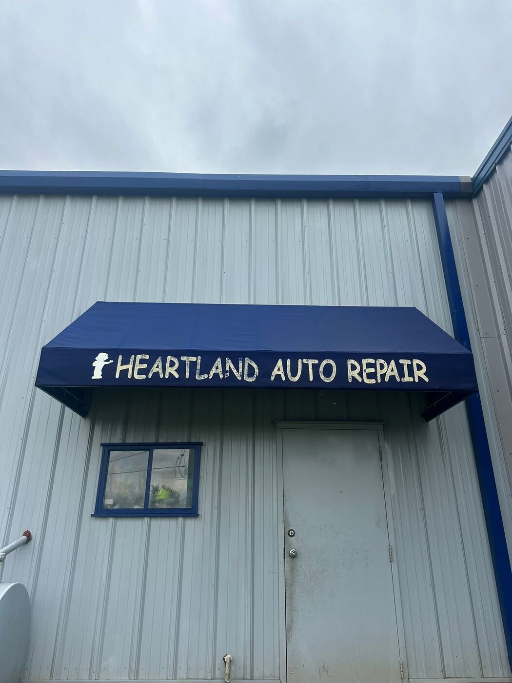 Shop awning after cleaning — navy fabric and white lettering bright again